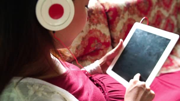 Νεαρή Έγκυος Γυναίκα Κάθεται Στον Καναπέ Ακούγοντας Μουσική — Αρχείο Βίντεο