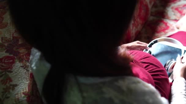 Νεαρή Έγκυος Γυναίκα Κάθεται Στον Καναπέ Ακούγοντας Μουσική — Αρχείο Βίντεο