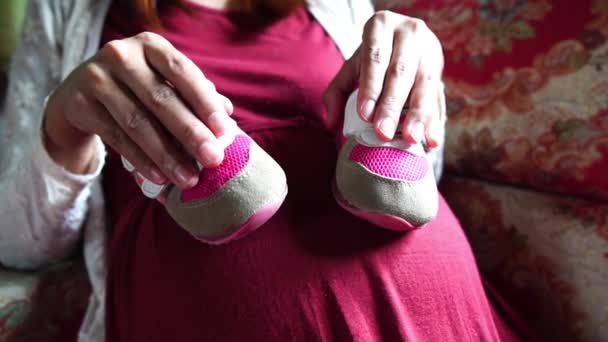 Young Pregnant Woman Holding Baby Booties — Stock Video