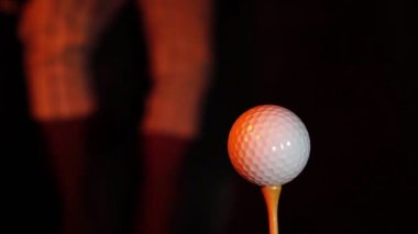 Golf topunun yanında yanan bir kulüp.