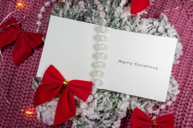 Boşluklu Noel kartı. Sıcak süveterinde tatil ışıkları olan kırmızı kurdeleler.