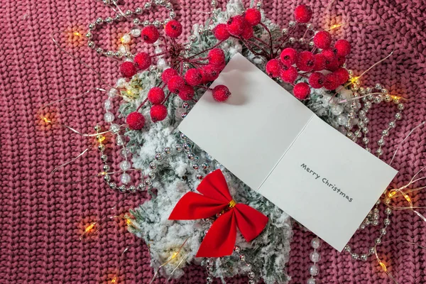 Kar ve kırmızı fiyonklu Noel ağacı dallarından yapılmış yaratıcı bir düzen ve kağıt kart notlu tatil ışıkları. Düz yatıyordu. Doğa Yeni Yıl Konsepti.