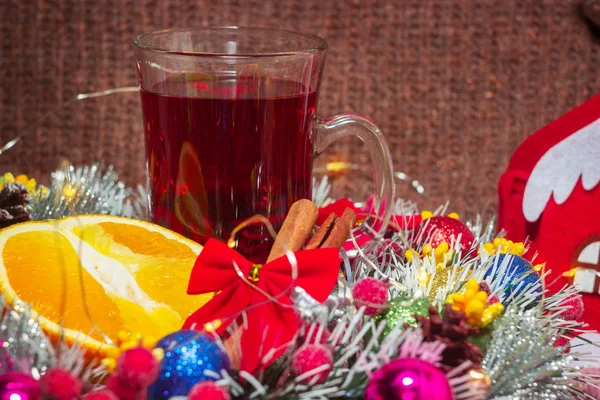 Bir kupa sıcak sıcak şarap dilimlenmiş narenciye ve tarçın çubuğu. Yeni yıl dekorasyonları için bir hediye zarfı. Noel konsepti