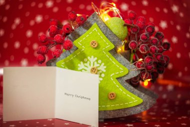 Noel hediyesi kartıyla yer değiştirip mesaj atıyorlar. Kırmızı arka planda tatil ışıkları ve fotokopi alanı olan yeni yıl dekorasyonları