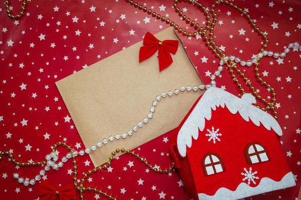 Süslemeli bir zarf içinde Noel tebrik kartı maketi, yıldızlı kırmızı bir zemin üzerinde düz yatış, metin için yer, düz yatış, üst manzara fotoğrafı maketi