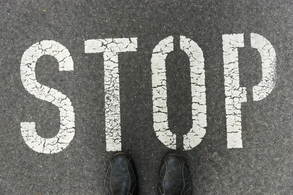 Wortstopp auf Asphaltstraße geschrieben — Stockfoto