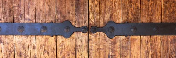 Fragment of closed wooden gate with metal fittings — Stock Photo, Image