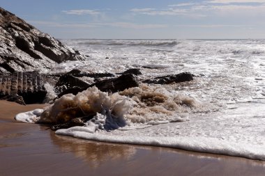 Sahilde Areia Branca dalgalar. Portekiz batı kıyısında