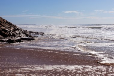 Sahilde Areia Branca dalgalar. Portekiz batı kıyısında