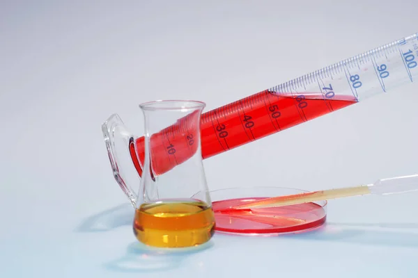 Measuring Cylinders, Glass Mug and pipette with liquids — Stock Photo, Image