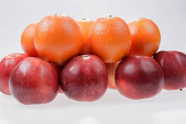 Rote Äpfel und Orangen — Stockfoto