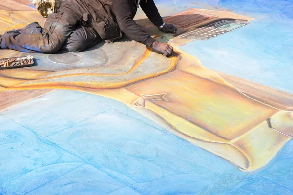 Мужчина уличный художник, работающий с мелом над картиной — стоковое фото