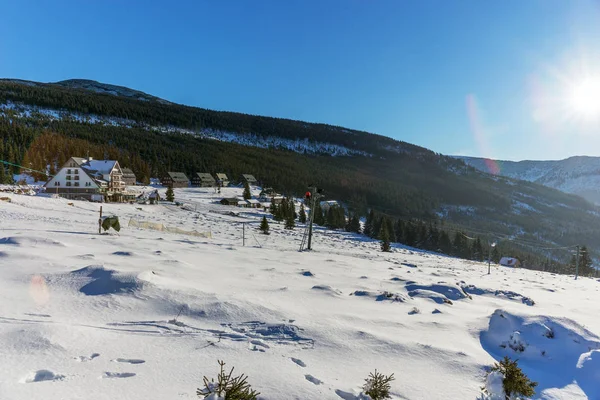 Ήλιο να λάμπει με φακό φωτοβολίδα πάνω από το χιόνι που καλύπτει γιγαντιαία βουνά — Φωτογραφία Αρχείου