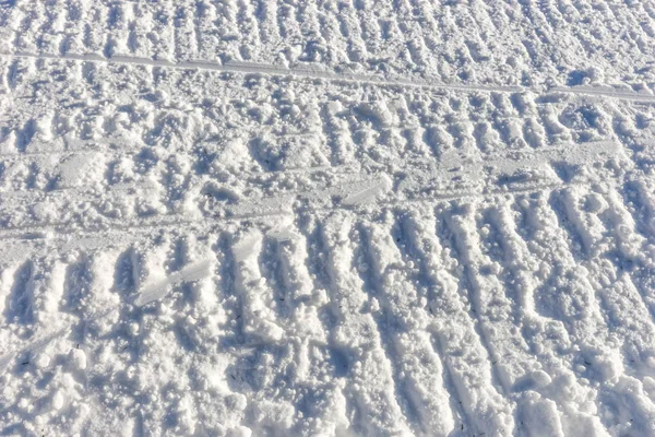 Huellas de moto de nieve en la nieve —  Fotos de Stock
