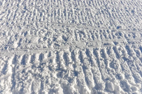 Huellas de moto de nieve en la nieve —  Fotos de Stock