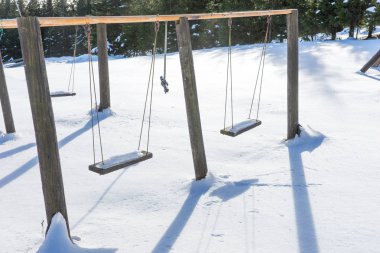 Kışın kar ile boş salıncak