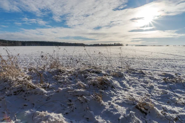 Небо с облаками и солнцем над снежным полем — стоковое фото