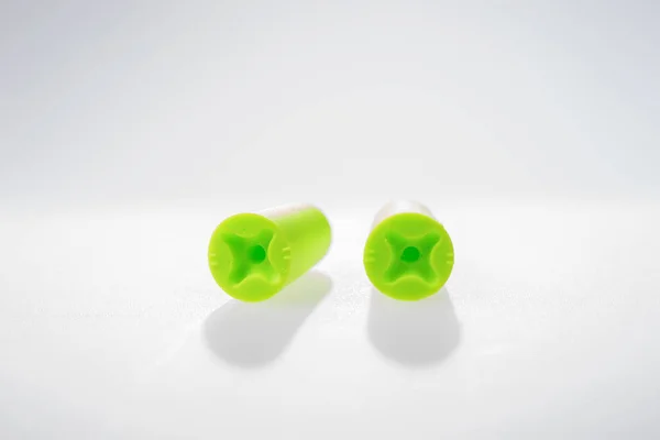 Два зеленых затычка для ушей, изолированных на белом — стоковое фото