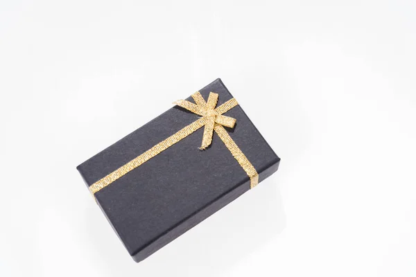 Zwarte geschenkdoos met gouden lint geïsoleerd — Stockfoto