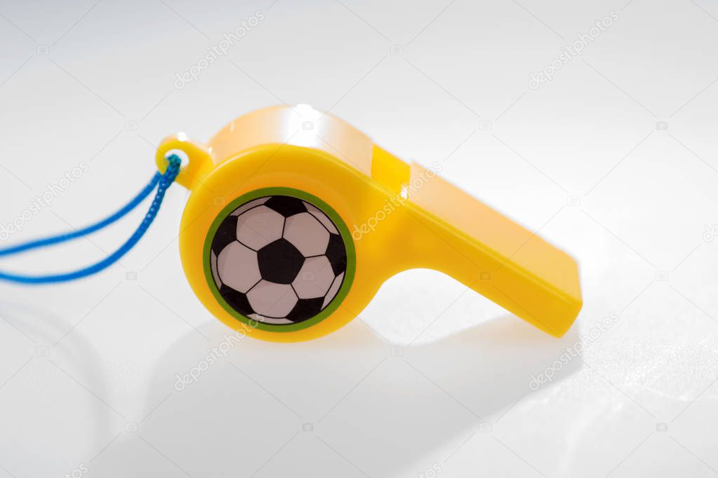 Colored plastic whistle with cord on white