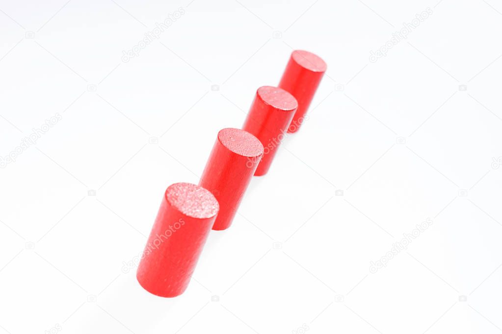 Four red round wooden building blocks in a row