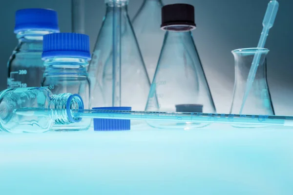 Glazen laboratoriumapparatuur op blauwe tafel — Stockfoto