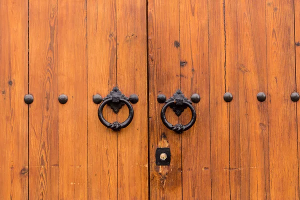 Antico cancello chiuso in legno con due anelli battente porta — Foto Stock