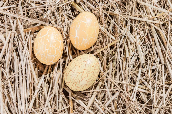 Tre uova di Pasqua gialle in paglia — Foto Stock