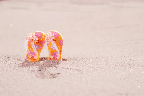 Bunte Flip-Flops mit Blumen am Strand — Stockfoto