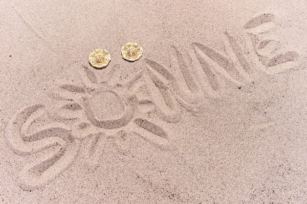 Palavra sol em alemão escrito na areia da praia — Fotografia de Stock
