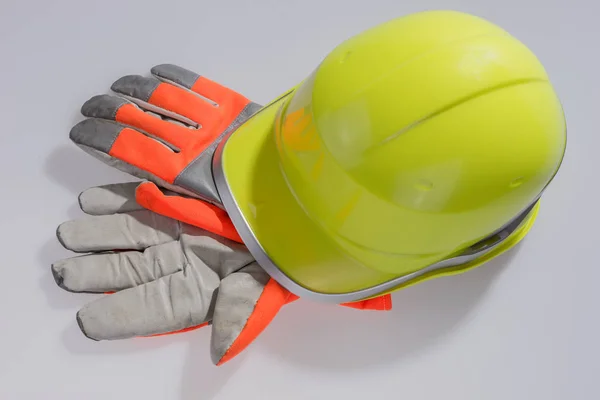 Casco giallo lavoro e guanti protettivi — Foto Stock