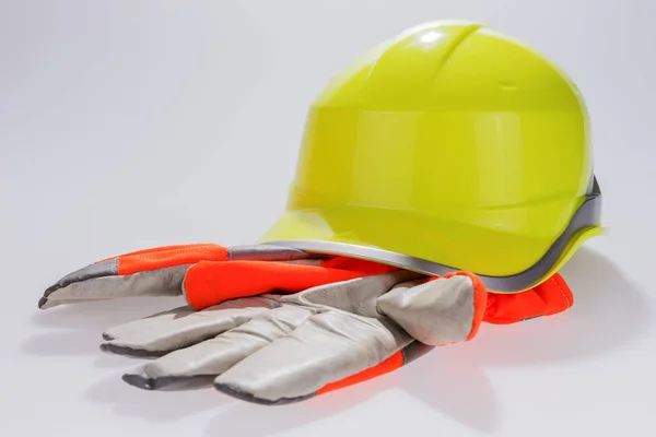 Casco giallo lavoro e guanti protettivi — Foto Stock