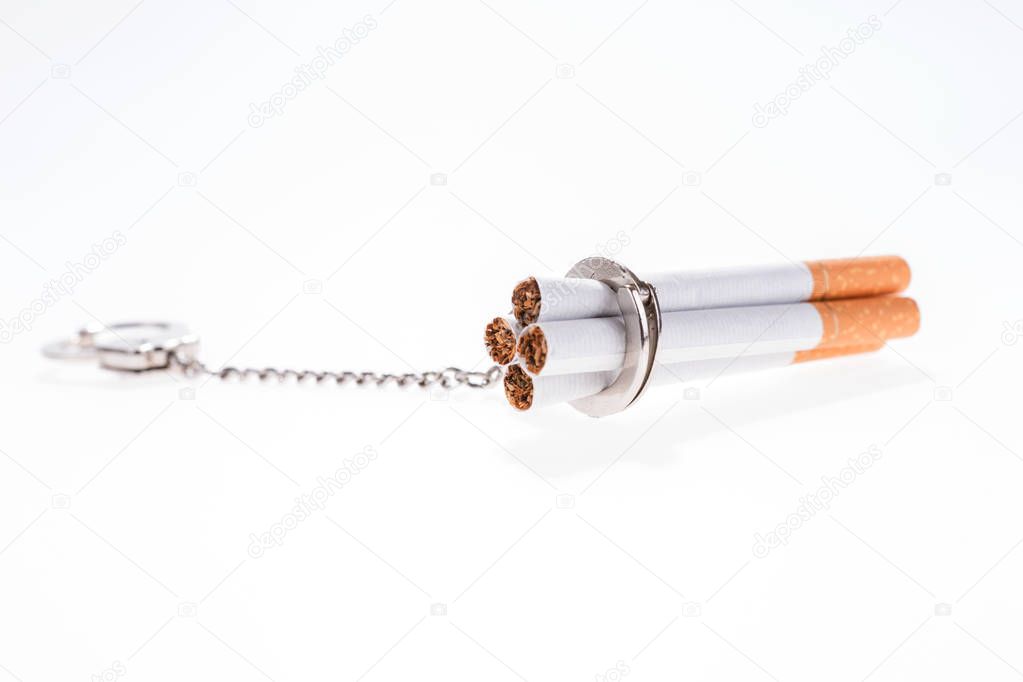 Addition concept with cigarettes and handcuffs on white