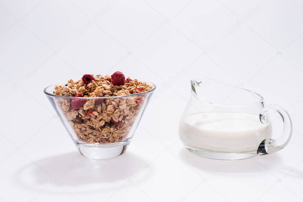 Muesli with red fruits and milk in glass isolated