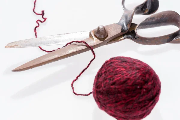 Tijeras y una bola roja de hilo de lana aislado — Foto de Stock