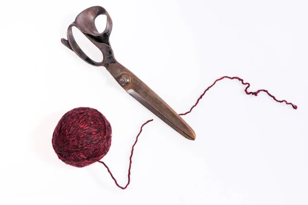 Nożyczki i czerwoną piłkę wełniane nici na białym tle — Zdjęcie stockowe