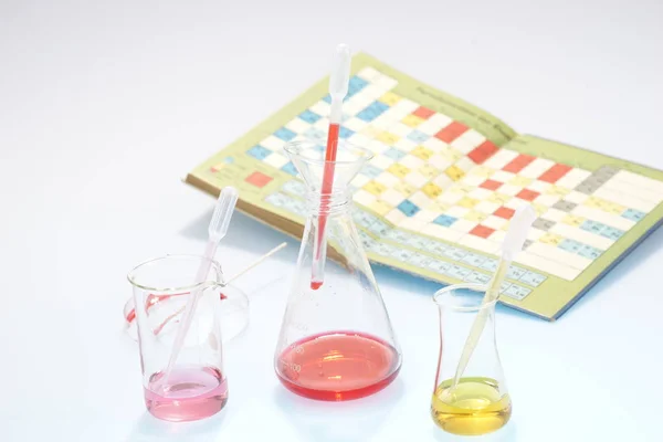 Laborgerät aus Glas mit Chemikalien und Buch — Stockfoto