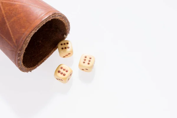 Three dice with leather cup on white — Stock Photo, Image