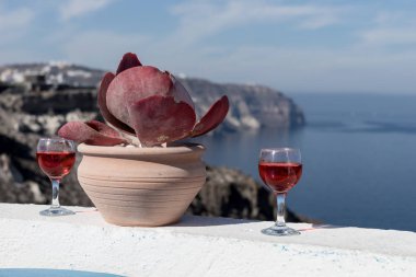 İki bardak lezzetli kırmızı şarap Santorini Adası denizin muhteşem manzaralı