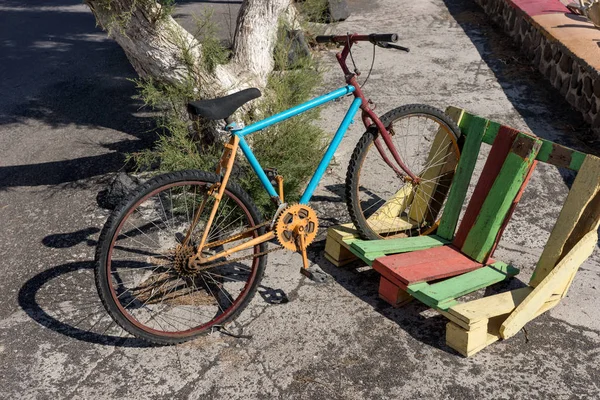 Buntes altes Fahrrad in Holzpaletten abgestellt — Stockfoto