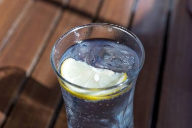 Masanın üzerine limon dilimi ve buz küpü ile su