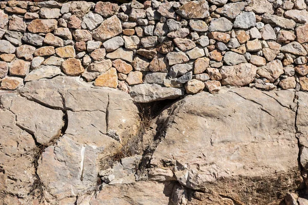 Pared de piedra natural con piedras pequeñas y grandes —  Fotos de Stock