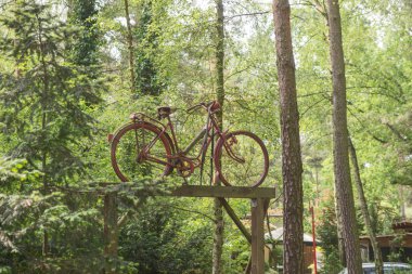 Dekorasyon olarak ahşap bir kiriş üzerinde eski paslı bisiklet