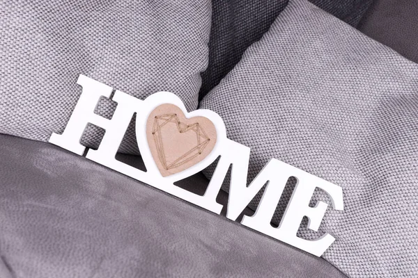 居心地の良いソファの上の装飾として白い文字で単語の家 — ストック写真