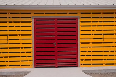 Modern sarı ahşap ambarda kırmızı kapı