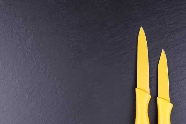 Dva Žluté Kuchyňské Nože Černé Břidlicové Desky — Stock fotografie