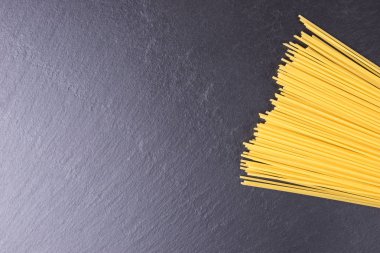 Siyah arduvaz plaka üzerinde sarı uzun ham spagetti