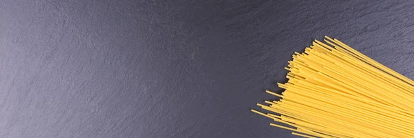 Желтое Сырое Спагетти Черной Плите — стоковое фото