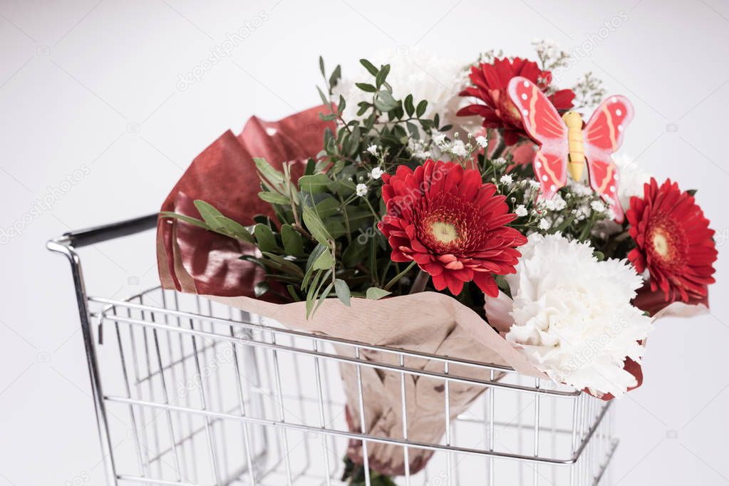 Bunch of beautiful flowers in shopping cart