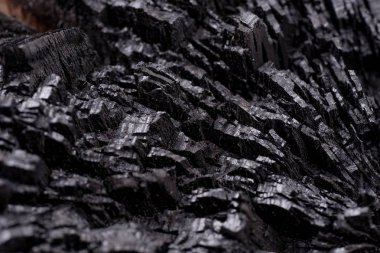 Siyah kömür arka planını kapatın. Ahşap kömür dokusu. Yanmış ağaç